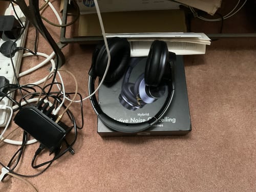 Auriculares Oneodio negros junto a un equipo de audio doméstico