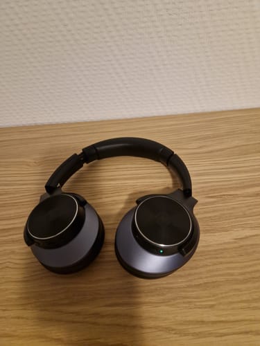 Auriculares Oneodio negros sobre una superficie de madera