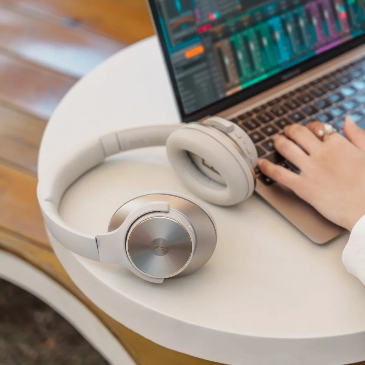 Fotografía original del anuncio de los auriculares plateados Oneodio junto a una computadora portátil