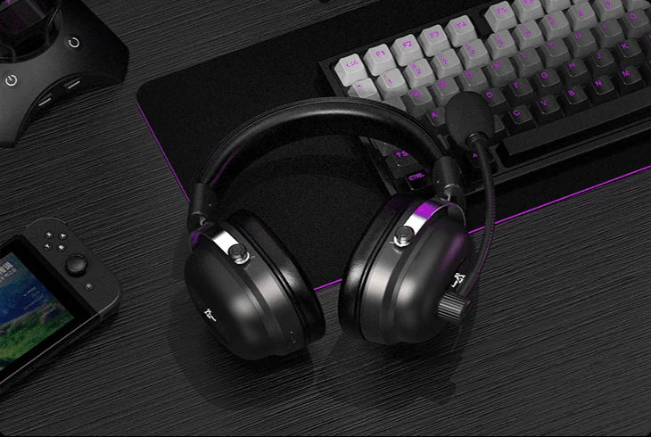 Cuffie Commander appoggiate su una scrivania tra una tastiera e una console portatile